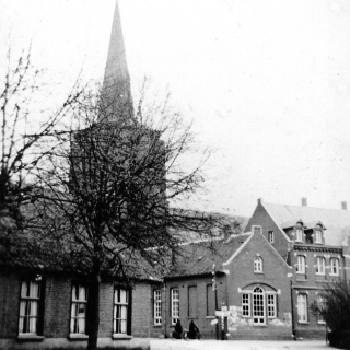 100-Oude kleuterschool in Bakel. Voor 1923 was het de meisjesschool. In de jaren zeventig van de vorige eeuw is dit pand, net als het gebouw ernaast, gesloopt. Op de voorgrond links op de foto café ‘t Gammele Geval.