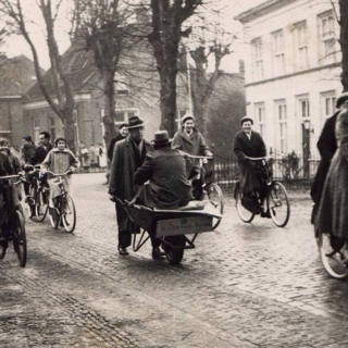 266-Een weddenschap op een autoloze zondag in 1956. W. Kuijpers van ’t Zand brengt hier J. Joosten van de Neerstraat in een kruiwagen naar de kerk in Bakel.