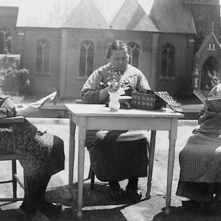 309-Senioren uit Maria-Oord. Op de achtergrond de kerk van Milheeze. Foto van vóór de verbouwing van de kerk in 1963.